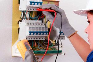 mujer electricista midiendo con el polimetro